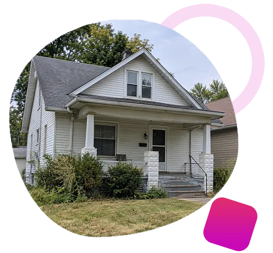 Older single-story white siding cottage with a front porch and overgrown yard in Clarksville, Indiana.