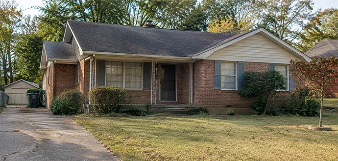 Single-story red brick ranch house with a paved driveway and lawn in Clarksville, Indiana.